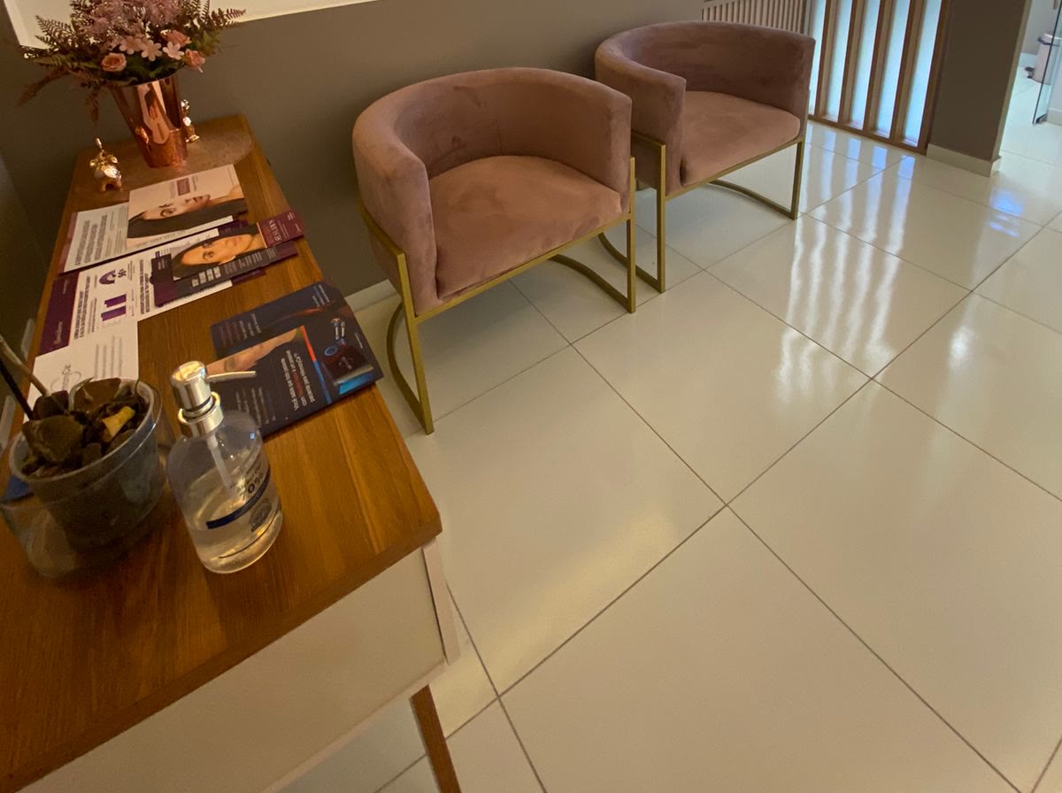 Sala de espera com mesa de apoio e poltronas rosé